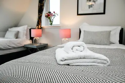 a bedroom with two beds with towels on them at Blackmount House in Oban
