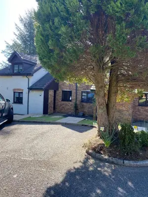 a car parked in front of a house with a tree at Gleneagles Holiday Home in Auchterarder