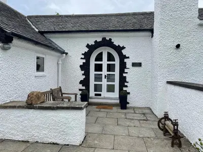 a bench in front of a white building with a window at Gate Lodge, House of Binns in Linlithgow