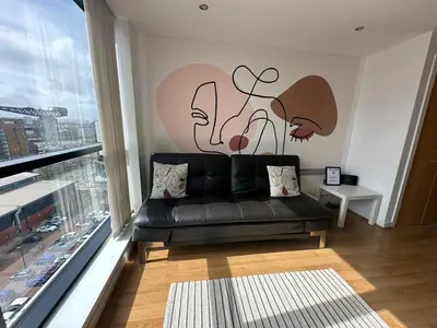 a living room with a black couch in front of a window at Cosy 1 bed next to SEC, OVO Hydro, Finnieston - Pass the Keys in Glasgow
