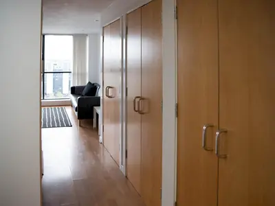 a hallway with wooden cabinets and a living room at Cosy 1 bed next to SEC, OVO Hydro, Finnieston - Pass the Keys in Glasgow