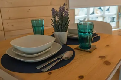 a table with plates and bowls and glasses on it at 1-Bed Cabin 2 Adults Outdoor Bath & Wood Burner in Carluke