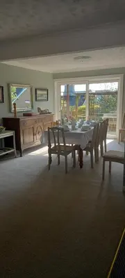 a dining room with a table and chairs and a piano at CORSBIE VILLA GUEST HOUSE in Newton Stewart