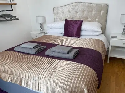 a bedroom with a large bed with two towels on it at Heart of George Street 2 in Oban