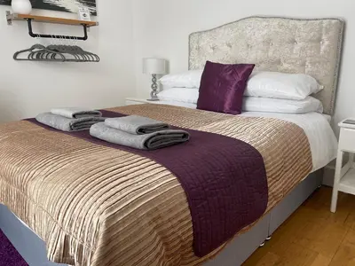 a bedroom with a large bed with towels on it at Heart of George Street 2 in Oban