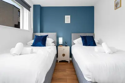 two beds in a room with blue walls at Cheerful Stays - Livingston - 4 Bedroom 3 Bath home in Livingston