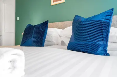 a bed with blue pillows on top of it at Cheerful Stays - Livingston - 4 Bedroom 3 Bath home in Livingston