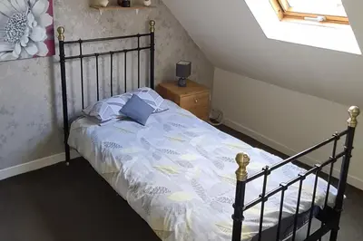 a bedroom with a bed with blue pillows on it at 4 Bed Cottage Sleeps 6-Pet-Friendly-Private Garden in Campbeltown