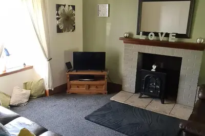 a living room with a fireplace and a television at 4 Bed Cottage Sleeps 6-Pet-Friendly-Private Garden in Campbeltown