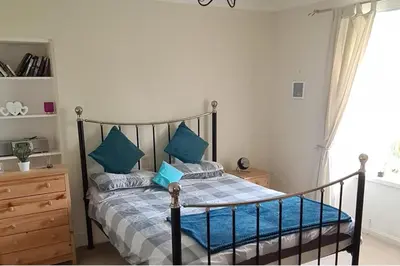 a bedroom with a bed with blue pillows at 4 Bed Cottage Sleeps 6-Pet-Friendly-Private Garden in Campbeltown