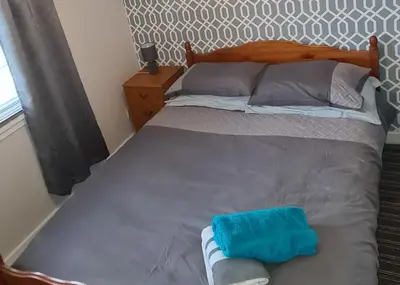 a bedroom with a bed with a blue towel on it at Beautiful 2-Bed Apartment in Campbeltown in Campbeltown