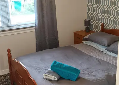 a bedroom with a bed with a blue towel on it at Beautiful 2-Bed Apartment in Campbeltown in Campbeltown