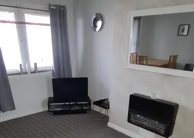 a living room with a television and a mirror at Beautiful 2-Bed Apartment in Campbeltown in Campbeltown