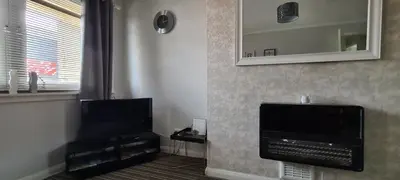 a living room with a flat screen tv and a mirror at Beautiful 2-Bed Apartment in Campbeltown in Campbeltown