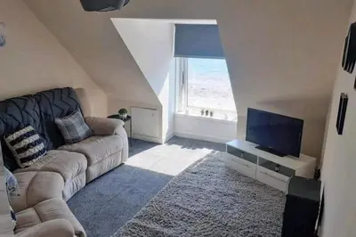 a living room with a couch and a flat screen tv at Loch Views Apartment Sleeps 2-Pets Ok-Free Parking in Campbeltown