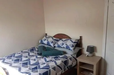 a bedroom with a bed with blue and white pillows at Loch Views Apartment Sleeps 2-Pets Ok-Free Parking in Campbeltown