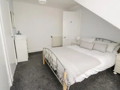 a white bedroom with a large bed in it at Willowbank in Ayr
