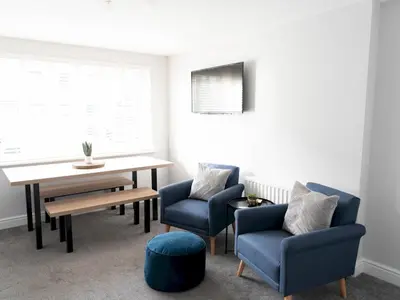 a dining room with a table and two chairs and a table and a tableearcher at Lovely, comfortable 2-bed Braehead - free parking - Pass the Keys in Renfrew