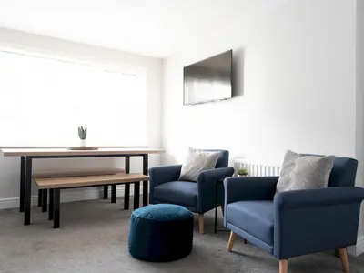 a living room with two blue chairs and a table at Lovely, comfortable 2-bed Braehead - free parking - Pass the Keys in Renfrew