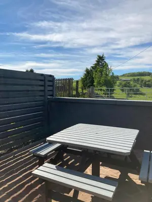 a picnic table and bench sitting on a deck at Westertonhill Holiday Lodges - Private Hot Tub Hire Available in Balloch