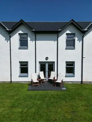 a group of chairs on a deck in front of a house at No 2 The Cairns, Unwind in Style in Oban