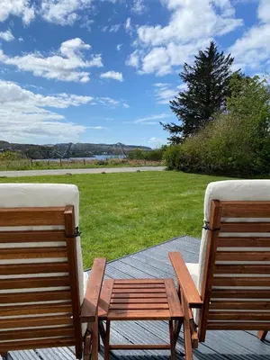 two chairs sitting on a patio with a field of grass at No 2 The Cairns, Unwind in Style in Oban
