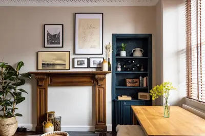 a living room with a fireplace and a table at The Wee Shop, Stylish Two Bed Flat in Inverkip Village in Inverkip
