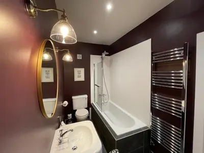 a bathroom with a sink and a tub and a toilet at The Wee Shop, Stylish Two Bed Flat in Inverkip Village in Inverkip