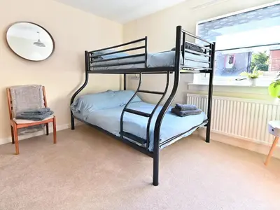 a bunk bed in a room with a chair and a mirror at Taigh An Uillt in Tighnabruaich