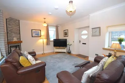 a living room with a couch and a television at Unique restored Old Post Office in Kinlochleven