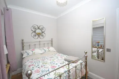a bedroom with a bed with a mirror on the wall at Unique restored Old Post Office in Kinlochleven