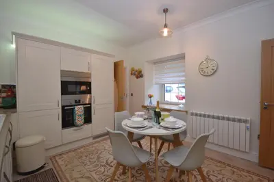 a kitchen and dining room with a table and chairs at Unique restored Old Post Office in Kinlochleven