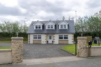 a large white house with a driveway at Higginsneuk in Airth