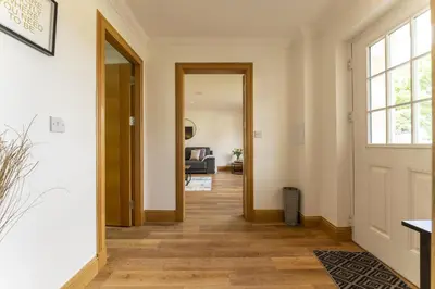an open hallway with a door to a living room at Higginsneuk in Airth