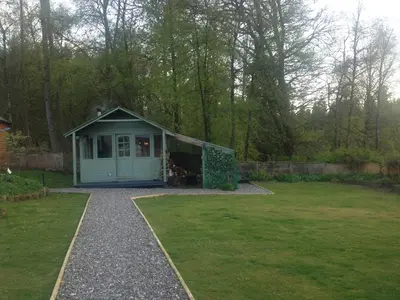 a small shed in a garden with a grass yard at Pinetree Cottage, dog friendly, Holiday let, Callander Invertrossachs in Callander