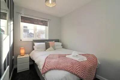 a small bedroom with a bed and a window at Signature - Chapelhall House in Chapelhall