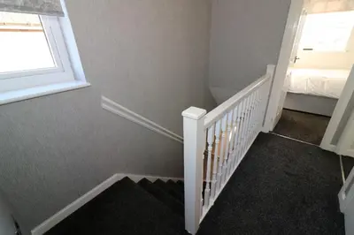 a bedroom with a staircase with a bed and a window at Signature - Chapelhall House in Chapelhall