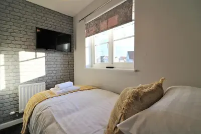 a bedroom with a bed and a brick wall at Signature - Chapelhall House in Chapelhall
