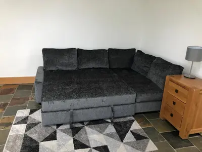 a couch in a living room with a table at The Cottage, near Glasgow Milngavie in Milngavie