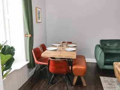 a dining room with a table and chairs at 40 Main Street in Burntisland
