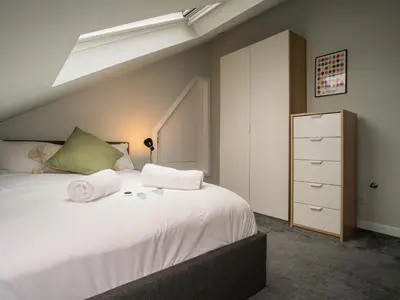 a bedroom with a large white bed with a skylight at 2BD Loft Style Apt - Edinburgh - Free Parking - Pass the Keys in Edinburgh