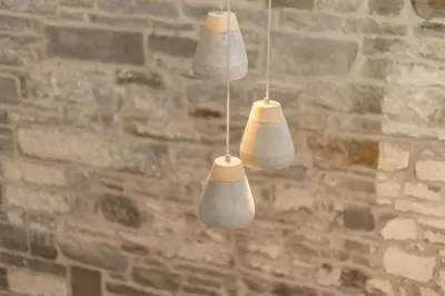 a group of four white lights hanging from a brick wall at 2BD Loft Style Apt - Edinburgh - Free Parking - Pass the Keys in Edinburgh