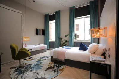 a bedroom with a bed and a desk and a chair at Revolver Glasgow in Glasgow