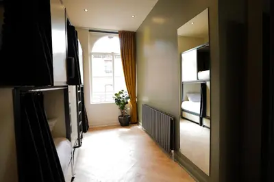 a room with a mirror and a bedroom with a bed at Revolver Glasgow in Glasgow
