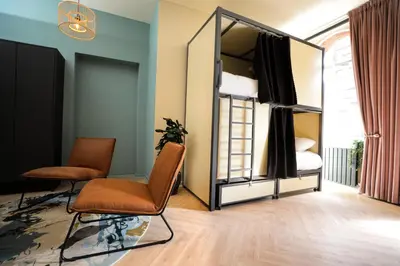 a room with a mirror and two chairs and a bed at Revolver Glasgow in Glasgow