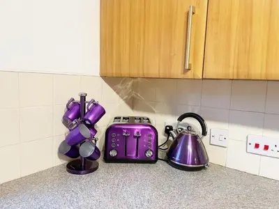a kitchen counter with purple appliances on a counter top at Cozy Nights SVP Detached House in Nitshill