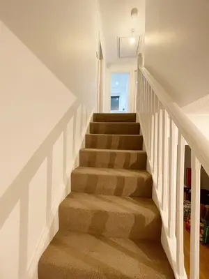 a staircase in a home with white walls at Cozy Nights SVP Detached House in Nitshill