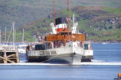 a ferry boat in the water near a dock at Tighnabruaich Duplex Apartment - Sea Views in Tighnabruaich