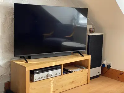 a flat screen tv sitting on a wooden entertainment center at Tighnabruaich Duplex Apartment - Sea Views in Tighnabruaich