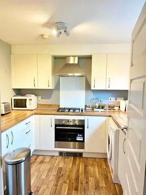 a kitchen with white cabinets and a stove top oven at Newbuild - 3 bedrooms, 2 baths,5 mins from airport in Edinburgh